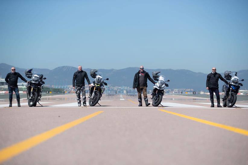 The 24 in 24 team stood on a runway with their bikes