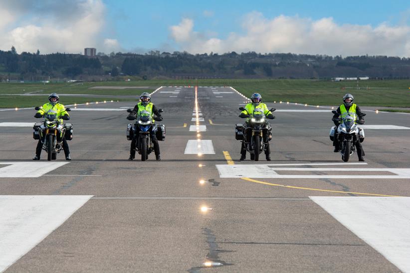 The 24 in 24 team line up on a runway on their bikes