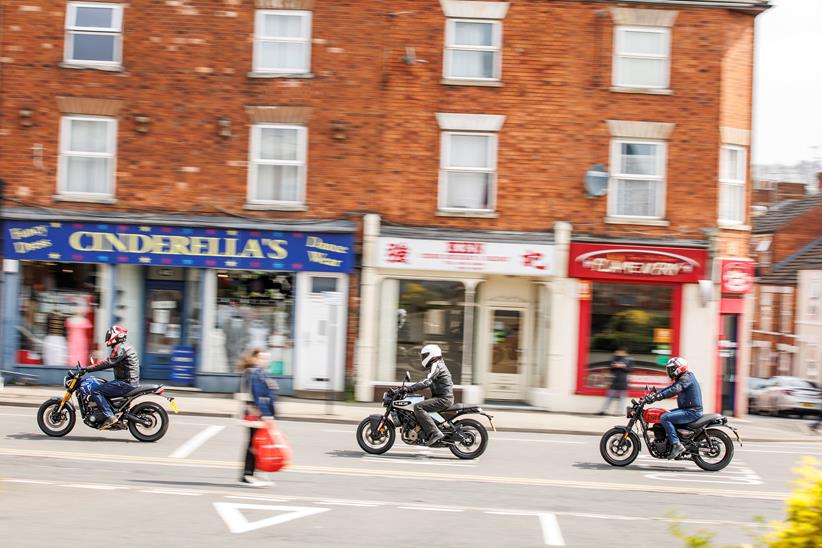 2024 Triumph Speed 400, Royal Enfield HNTR 350, Husqvarna Vitpilen 401 Group Test - riding past the shops