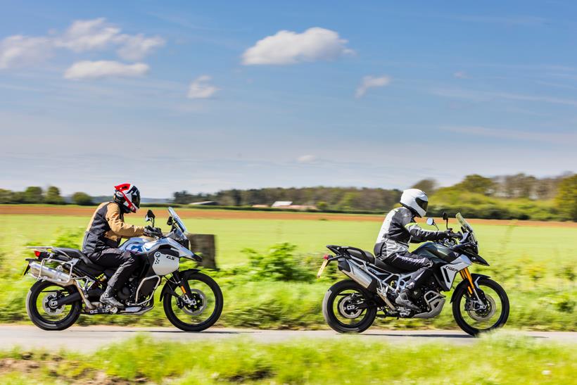 2024 BMW F900GSA and Triumph Tiger 900 Rally Pro - riding in line down a country road 