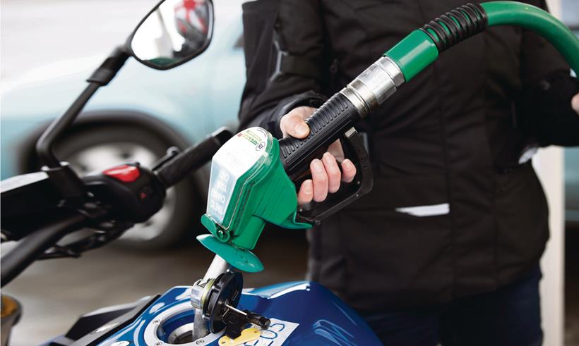 Motorcycle petrol tank being filled at a petrol station