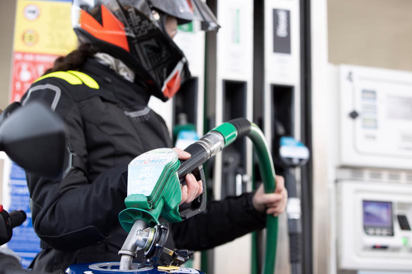 Motorcycle rider fills bike with petrol