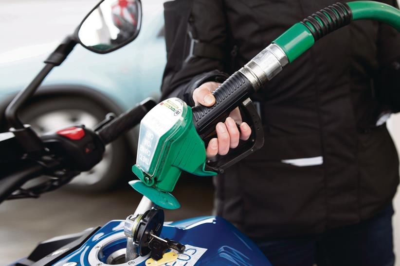 Motorcycle petrol tank being filled at a petrol station