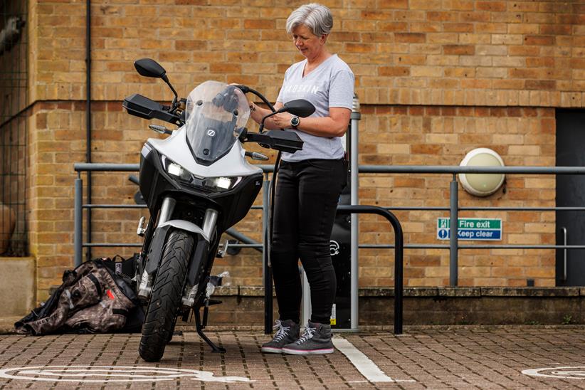 Plugging in an electric motorcycle to charge