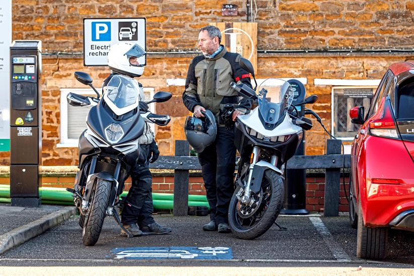 Charging an electric bike next to a petrol motorcycle