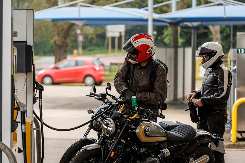 Two riders filling up the 2024 BMW R12 and the 2024 Harley-Davidson Nightster Special