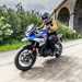 2024 BMW F800GS being ridden on a country road underneath a bridge