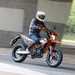 2024 KTM 690 SMC R riding on a road in an urban setting