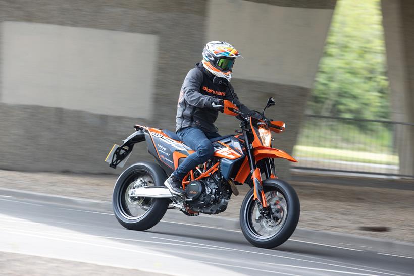 2024 KTM 690 SMC R riding on a road in an urban setting