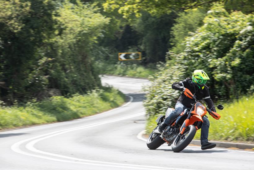 2024 KTM 690 SMC R cornering on a country road