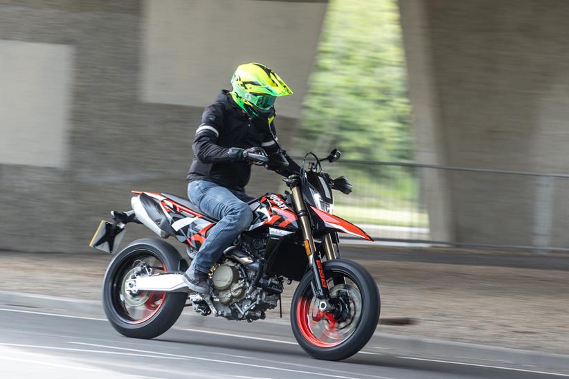 2024 Ducati Hypermotard 698 Mono RVE riding on a road in an urban setting