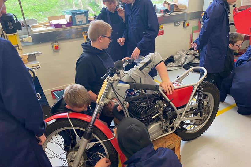 Kids working on Suzuki TS185 at school