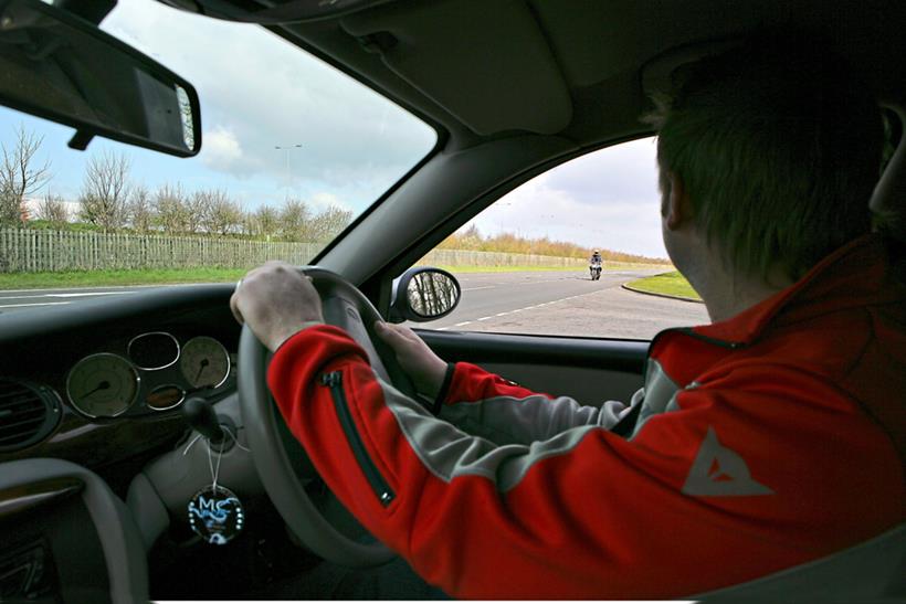 Car driver looks at motorcyclist at junction