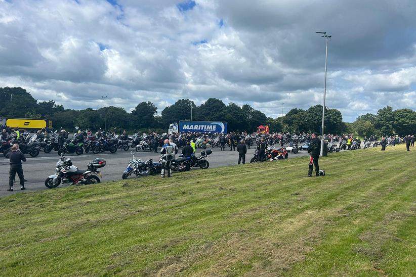 Large crowd of motorcyclists gather alongside a road - Credit Heather Airey