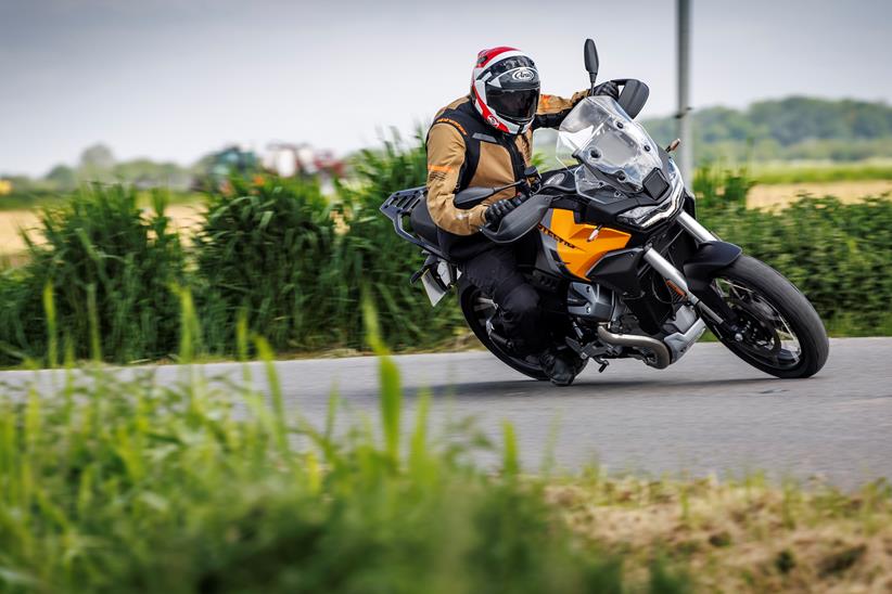 The Moto Guzzi Stelvio leaning hard into a grassy corner bend