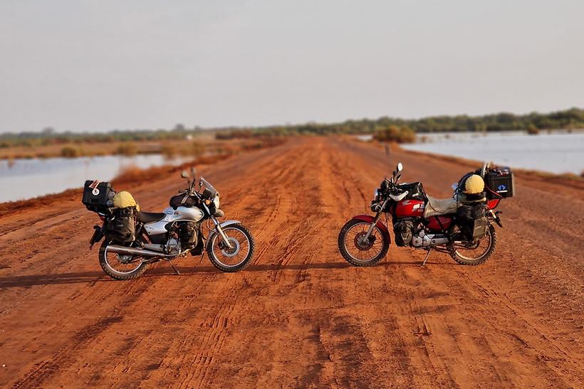 Honda CG125s parked up on a dirt track