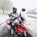 Snow falling around a pair of motorcyclists