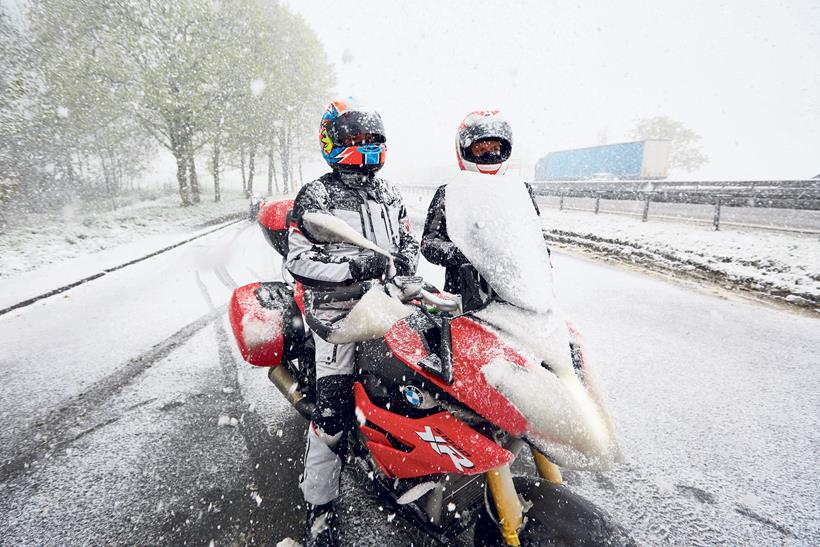 Snow falling around a pair of motorcyclists