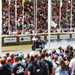 Crowd watch racer perform a rolling burnout aboard an Indian motorcycle at Goodwood Festival of Speed