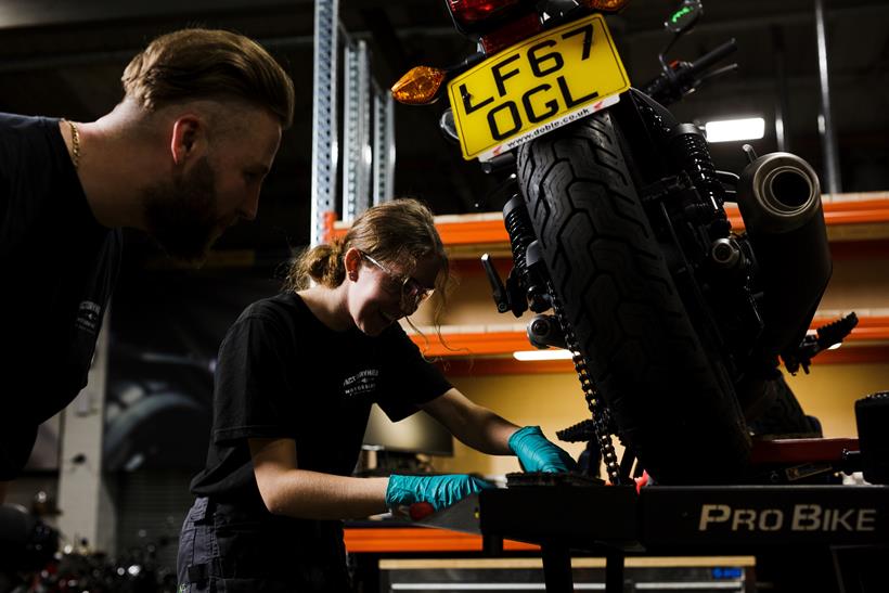 SuperBike Factory apprentice with instructor looking at bike