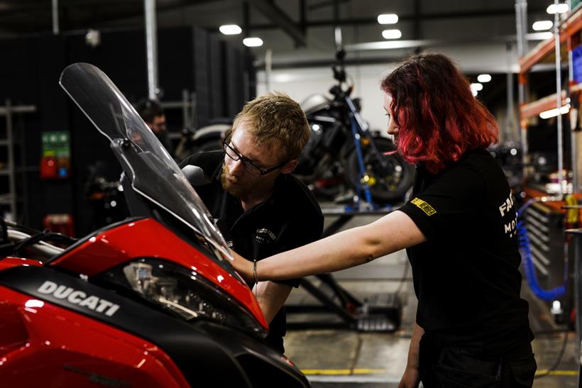 SuperBike Factory apprentice with instructor looking at bike