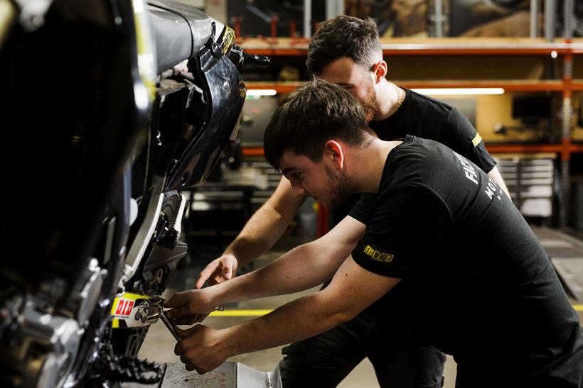 SuperBike Factory apprentice with instructor looking at bike