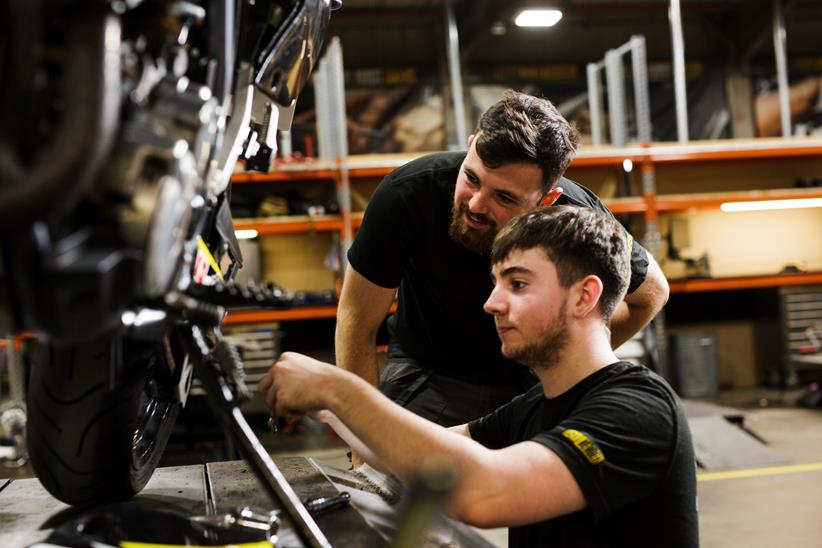 Superbike Factory Apprentice with instructor looking at bike