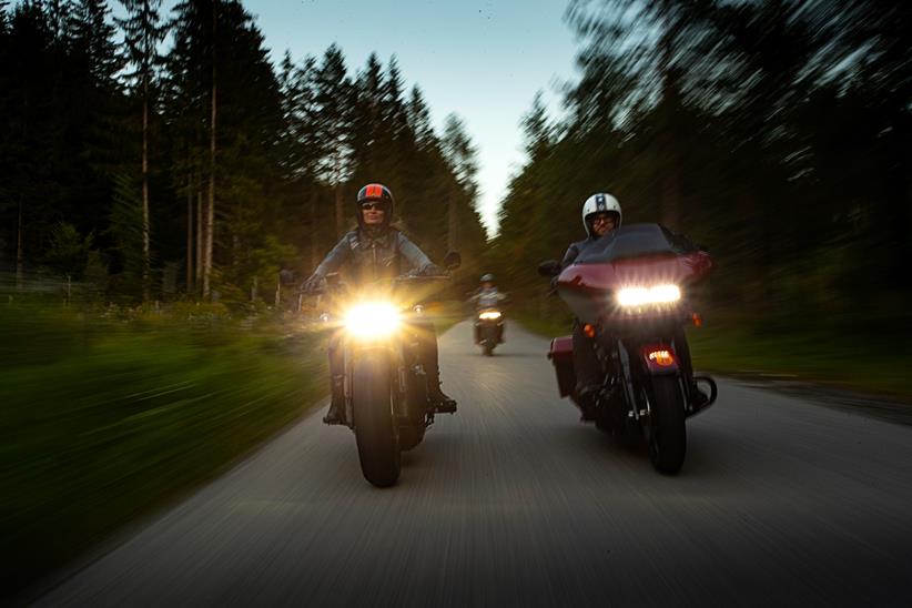 Harley-Davidson riders on the road at dusk