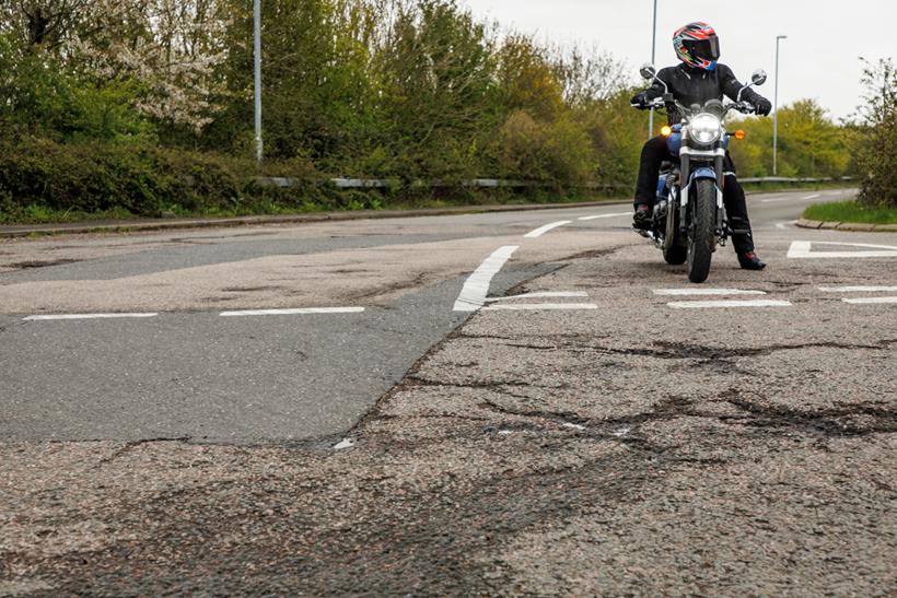 Biker on road in poor state of repair