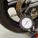 Checking a motorcycle tyre's pressure with a pressure gauge