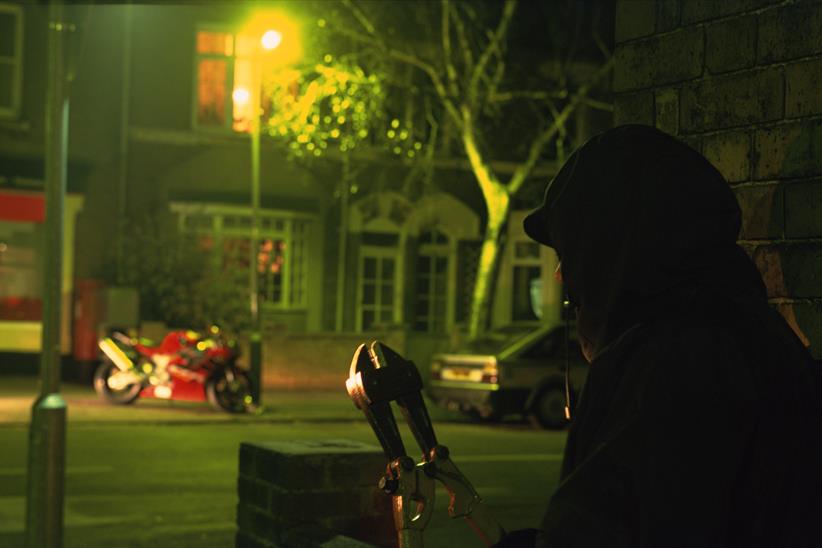 A motorbike thief prepares to steal a motorbike