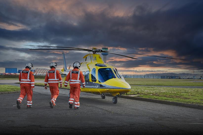 Three people walking towards helicopter