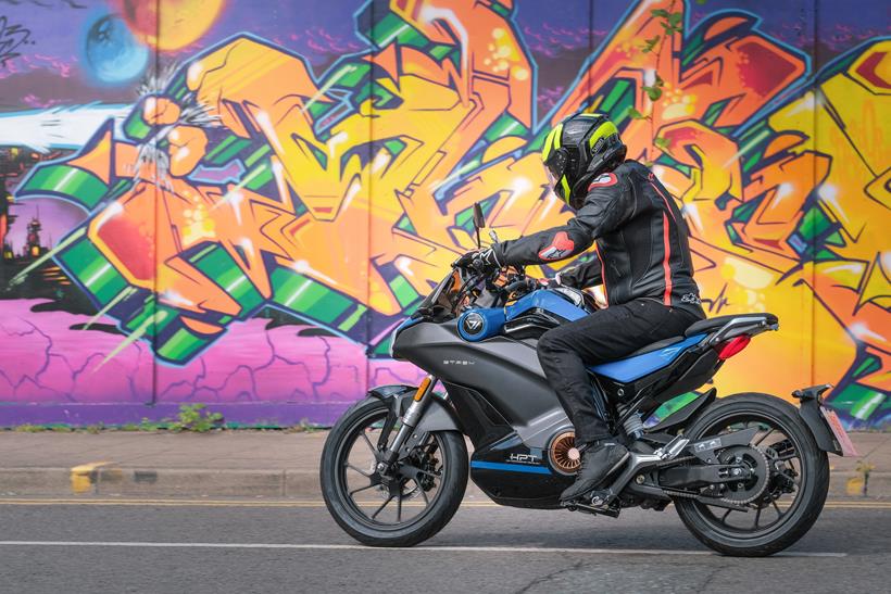 2024-on Vmoto Stash riding past bright graffiti