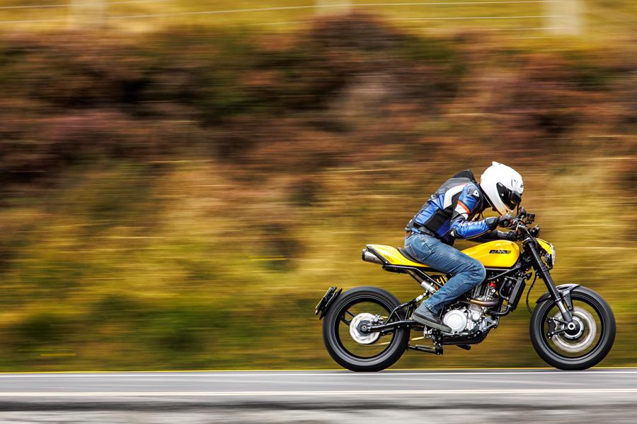 2025-on CCM Street Moto R riding past on a country lane