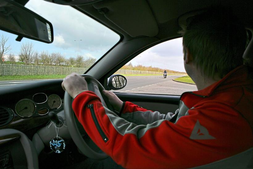 Car driver looking at approaching motorcyclist