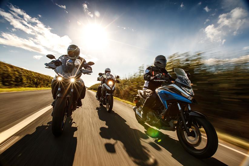 Three motorcycle riders with the sun behind them