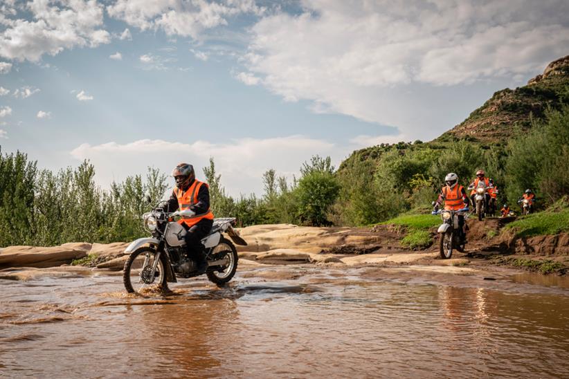 Riders for Health riders crossing river