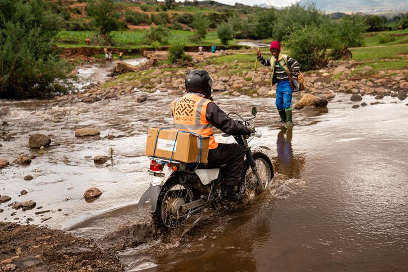 Riders for Health rider crossing river