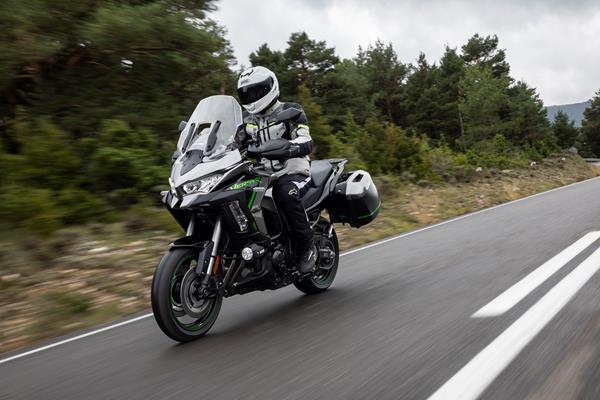 2025-on Kawasaki Versys 1100 SE touring down a tree lined road