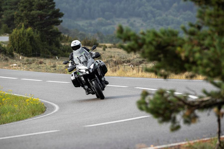 2025-on Kawasaki Versys 1100 SE leaning into a corner with panniers on