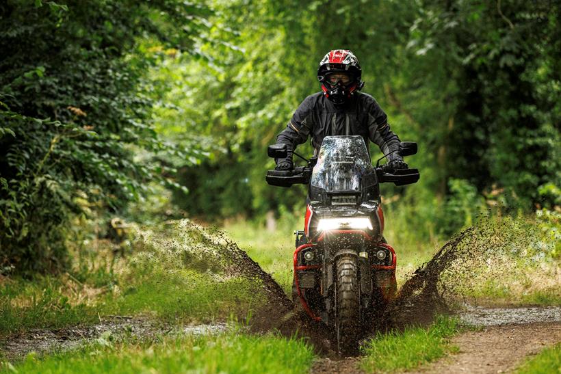 Justin Hayzelden riding through a muddy ridge on-trail