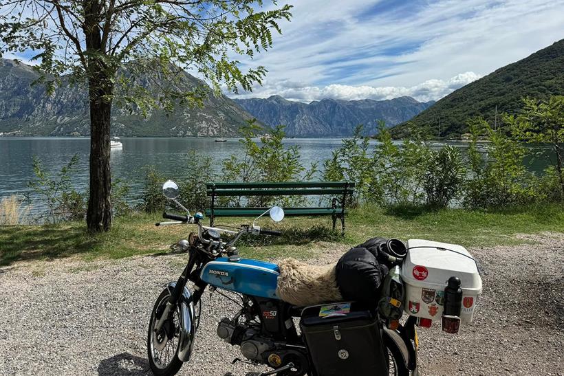 Honda SS50 parked up by a lake