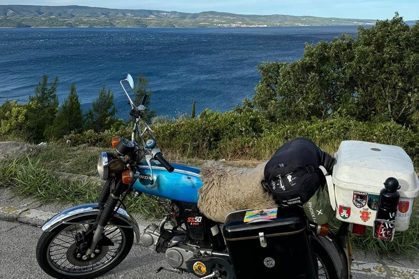 Honda SS50 parked up by the sea