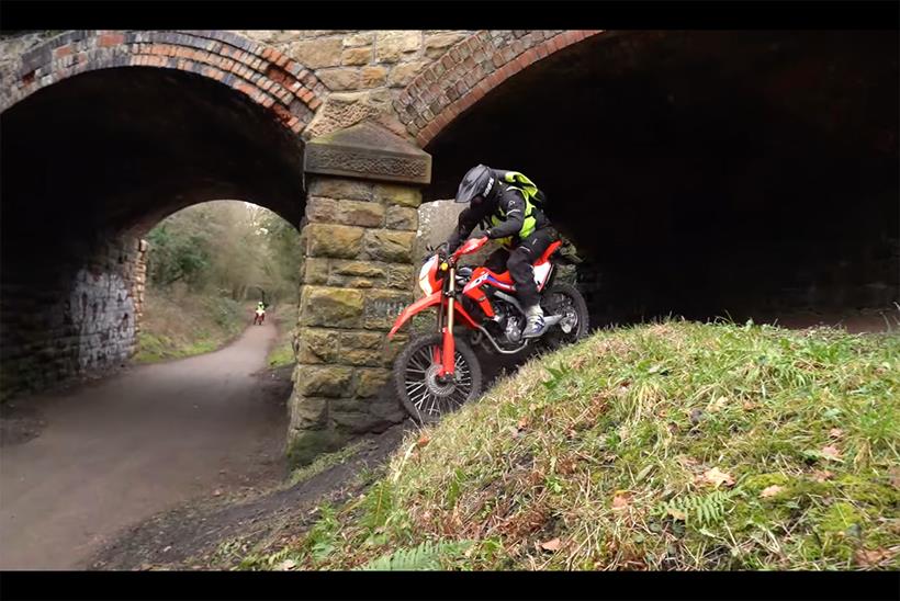 Police off-road motorcyclist riding down slope on Honda CRF300L