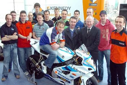 Clerk of the Course, Mervyn White, is surrounded by a host of NW200 stars 