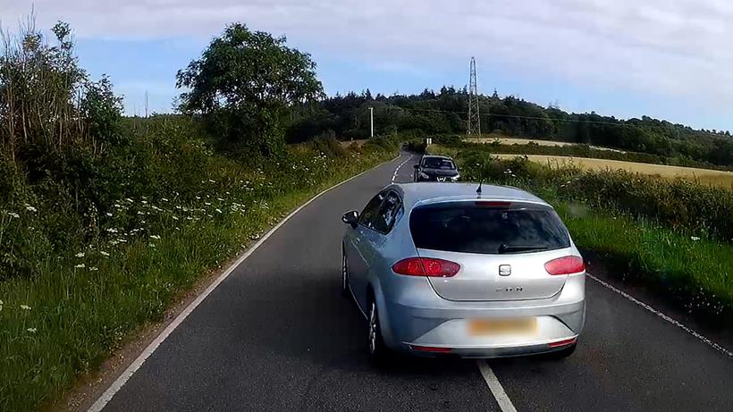 Une voiture effectue un dépassement dangereux sur une route