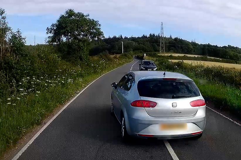 Une voiture effectue un dépassement dangereux sur une route