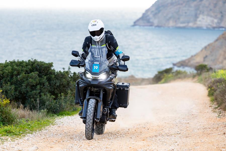 2025-on CF Moto 700MT - head on shot riding up a gravel track