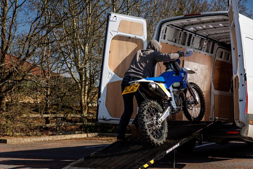 Husqvarna enduro bike being loaded into van 
