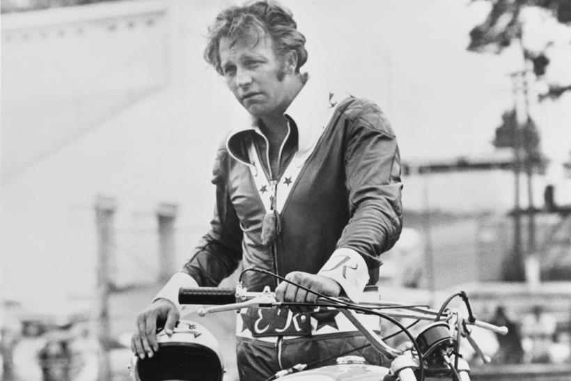 Evel Knievel stood with a motorcycle